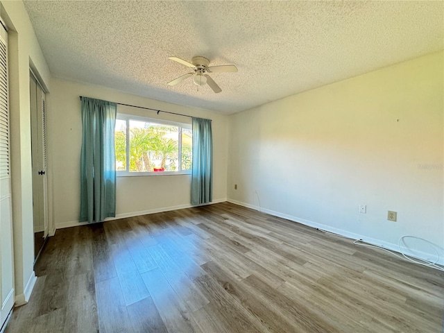 empty room featuring ceiling fan, light hardwood / wood-style floors, and a textured ceiling