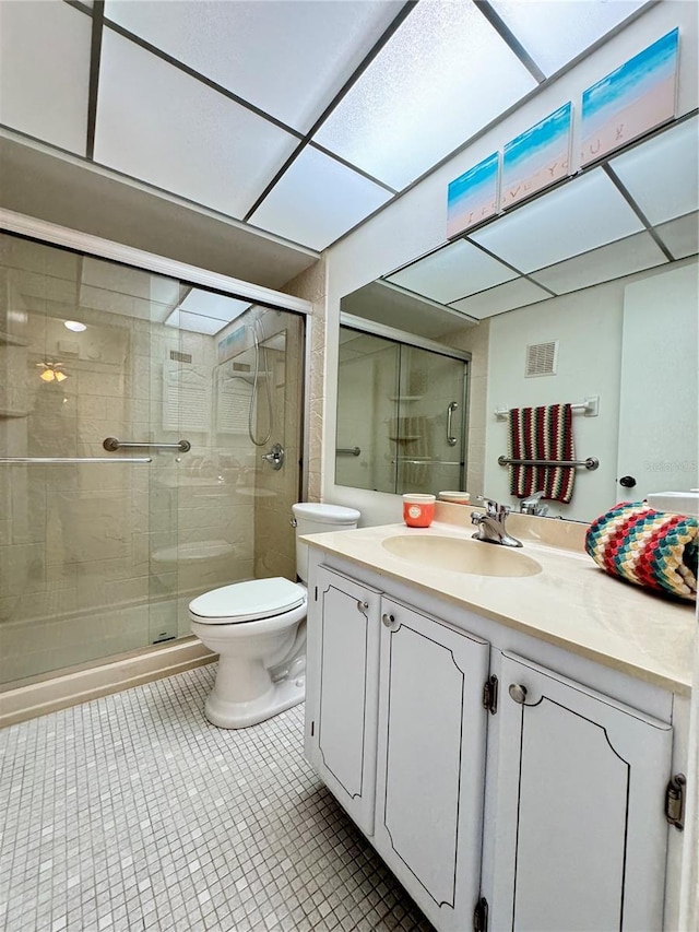 bathroom featuring vanity, an enclosed shower, and toilet