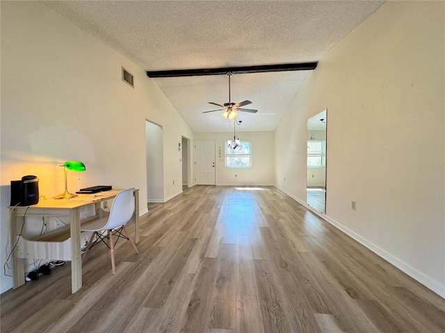 unfurnished living room featuring ceiling fan with notable chandelier, lofted ceiling with beams, a textured ceiling, and light wood-type flooring