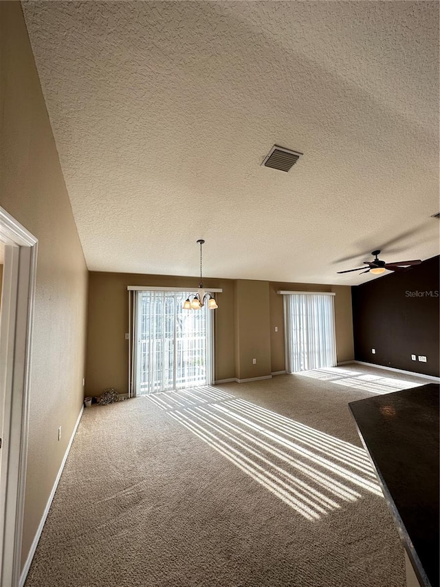 carpeted spare room featuring ceiling fan and a textured ceiling