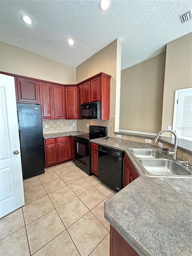 kitchen featuring tasteful backsplash, sink, light tile patterned floors, and black appliances