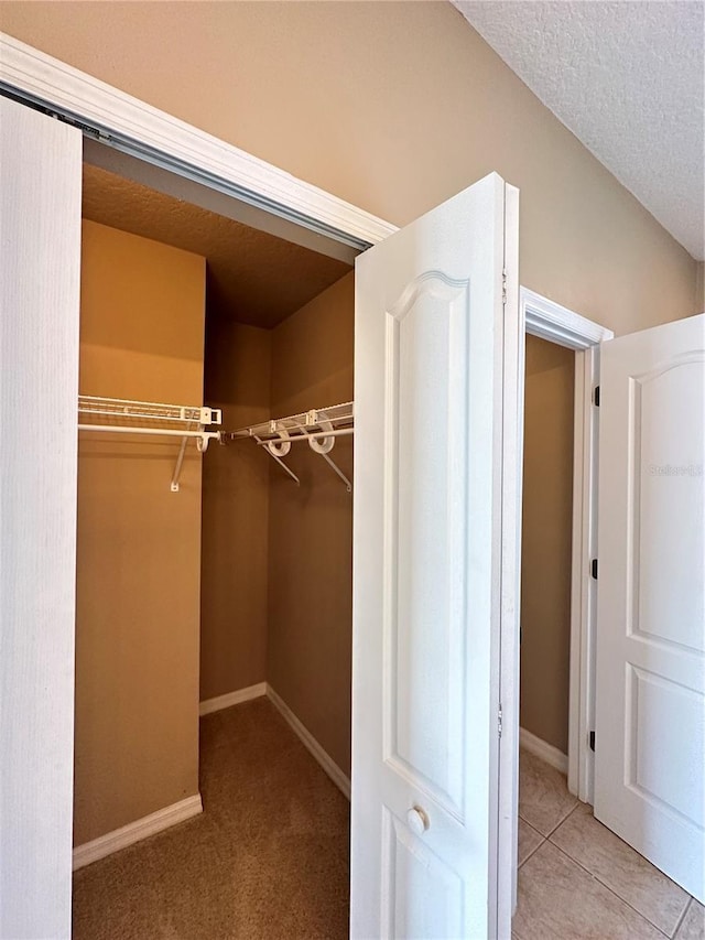 walk in closet with light tile patterned flooring