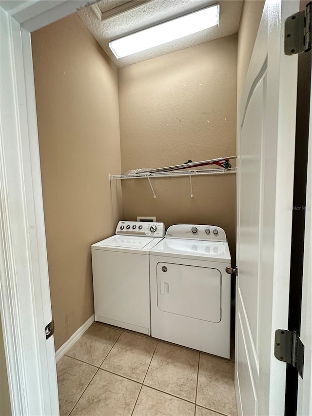 laundry room with independent washer and dryer and light tile patterned flooring