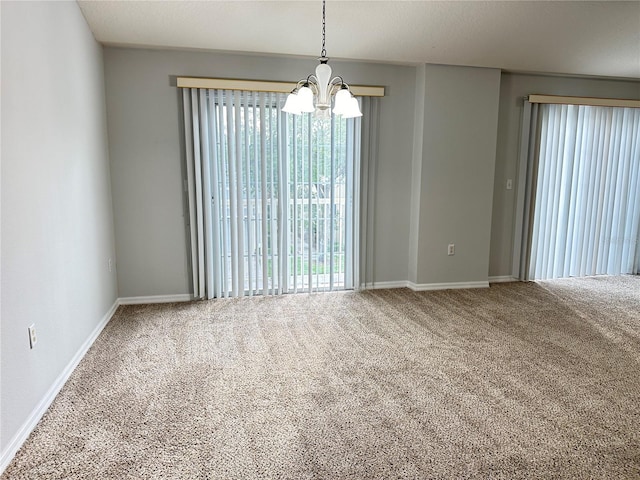unfurnished room featuring baseboards, a notable chandelier, and carpet