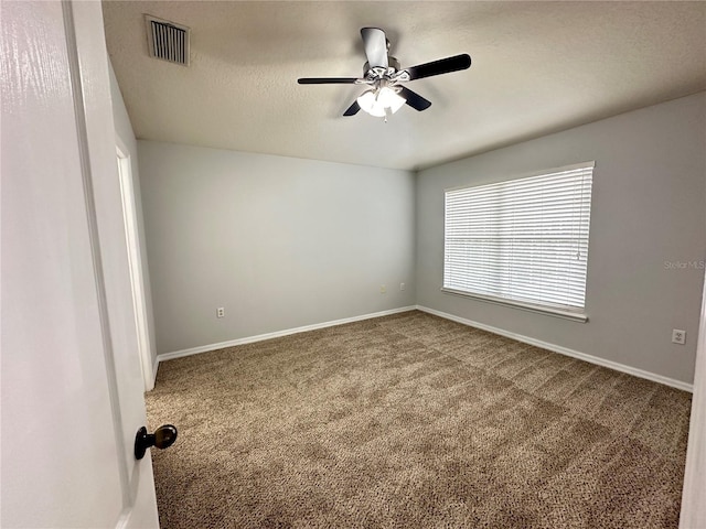 carpeted spare room featuring a ceiling fan, baseboards, and visible vents