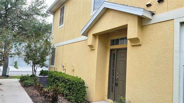 property entrance with central AC and stucco siding