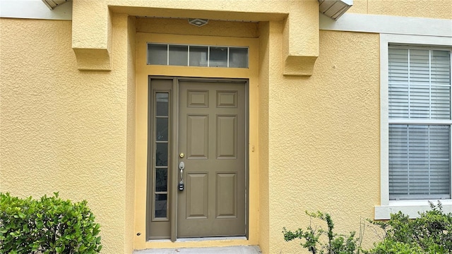 property entrance with stucco siding