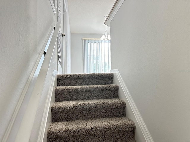 staircase featuring an inviting chandelier