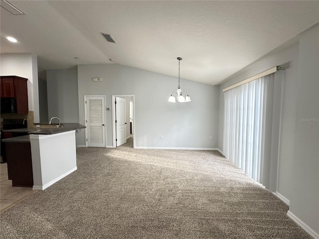 kitchen with dark countertops, light carpet, a chandelier, lofted ceiling, and black microwave