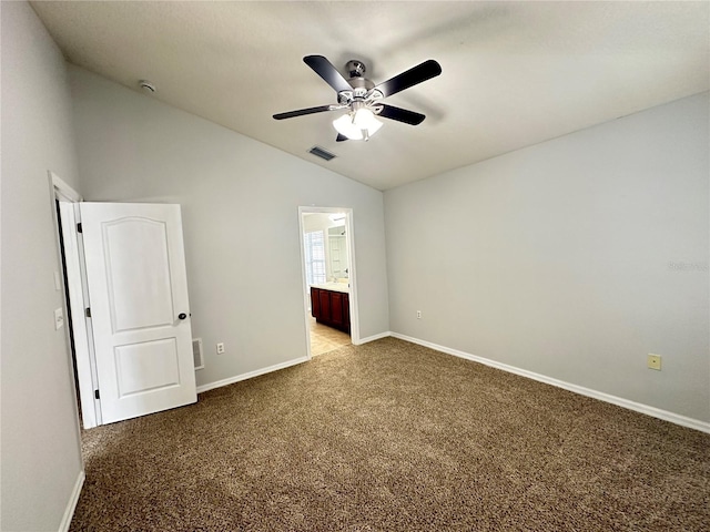 spare room featuring a ceiling fan, lofted ceiling, baseboards, visible vents, and light colored carpet