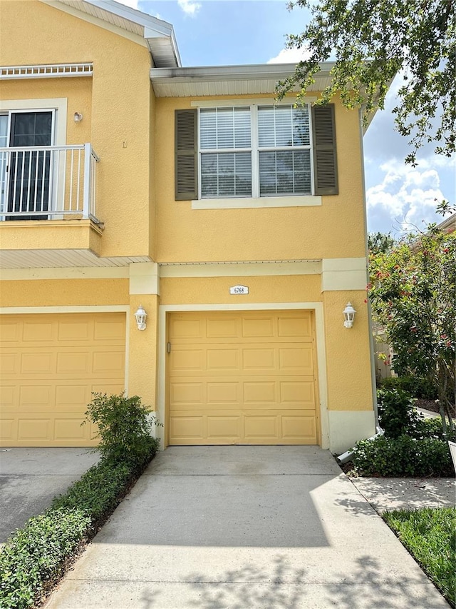 6768 Breezy Palm Dr, Riverview, FL 33578 - view of property with an attached garage, concrete driveway, stucco siding, and a balcony