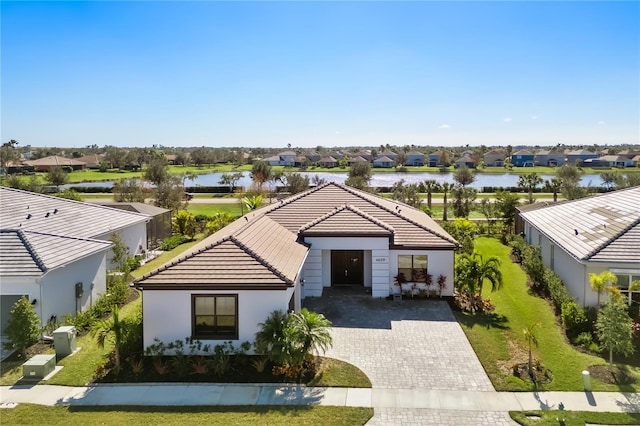 view of front of property featuring a water view and a front lawn