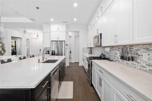 kitchen with hanging light fixtures, white cabinets, and appliances with stainless steel finishes