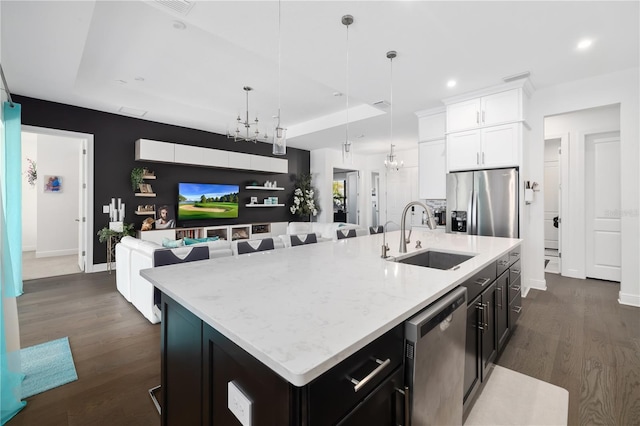 kitchen with sink, stainless steel appliances, a chandelier, and a center island with sink