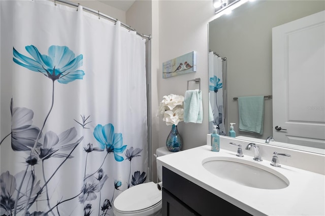 bathroom featuring vanity, walk in shower, and toilet