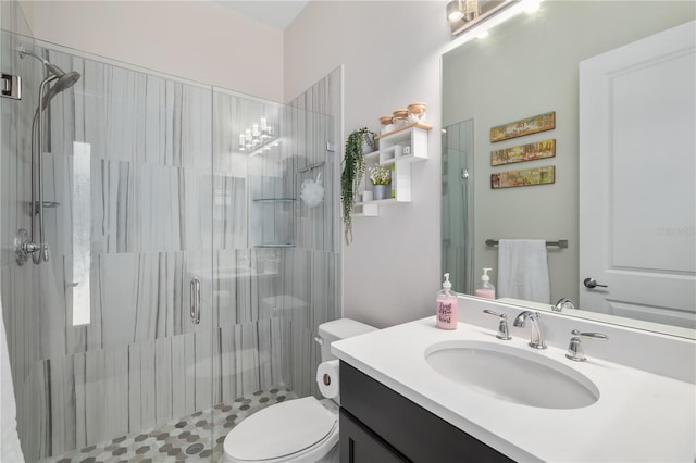 bathroom featuring vanity, toilet, and a shower with door