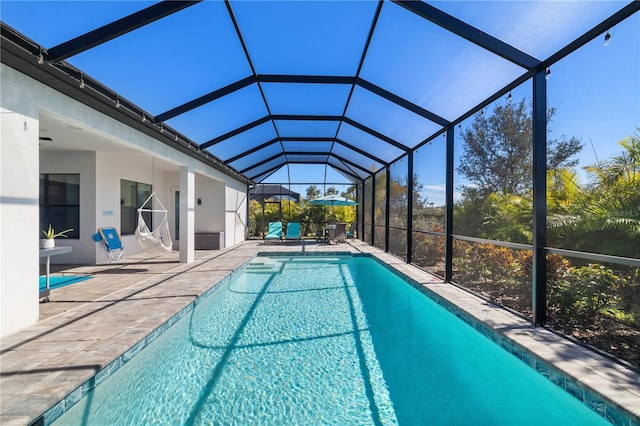 view of swimming pool with a patio area and glass enclosure