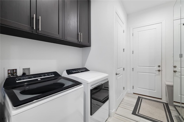 washroom featuring cabinets and washing machine and clothes dryer