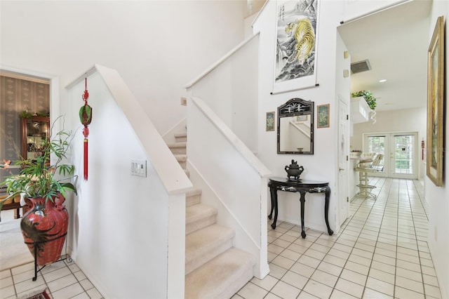 stairway featuring tile patterned flooring and french doors