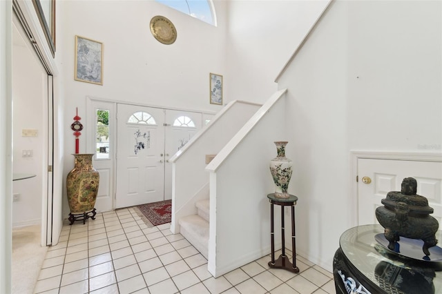 entrance foyer featuring light tile patterned floors, a high ceiling, and plenty of natural light