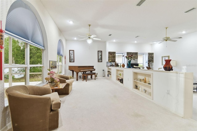 living area with carpet flooring, ceiling fan, and built in shelves