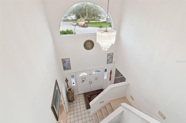 entrance foyer featuring a high ceiling, tile patterned floors, and a chandelier