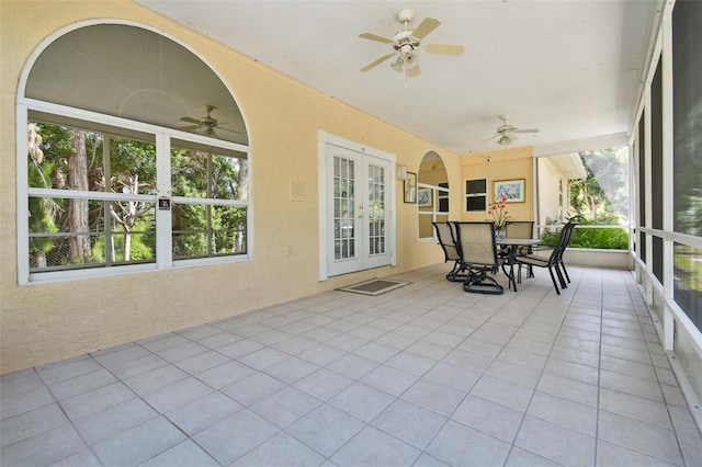 sunroom featuring ceiling fan and french doors