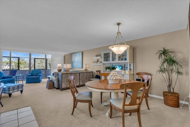 dining space featuring light colored carpet and a textured ceiling