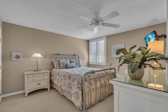 carpeted bedroom featuring ceiling fan and a textured ceiling