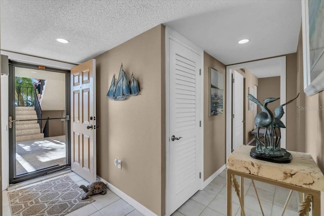 tiled foyer with a textured ceiling