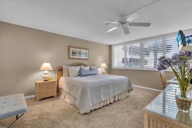 bedroom featuring ceiling fan, light colored carpet, and a textured ceiling