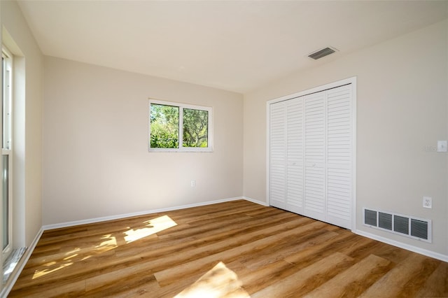 unfurnished bedroom featuring wood-type flooring and a closet