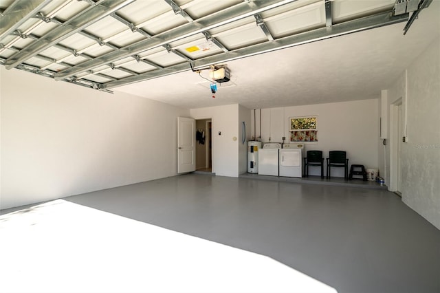 garage with a garage door opener, washing machine and dryer, and electric water heater