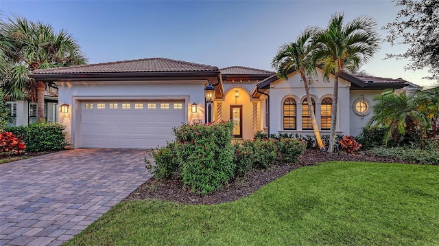 mediterranean / spanish-style home featuring a yard and a garage