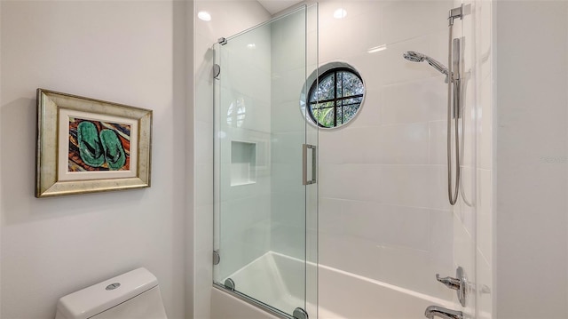 bathroom with combined bath / shower with glass door and toilet