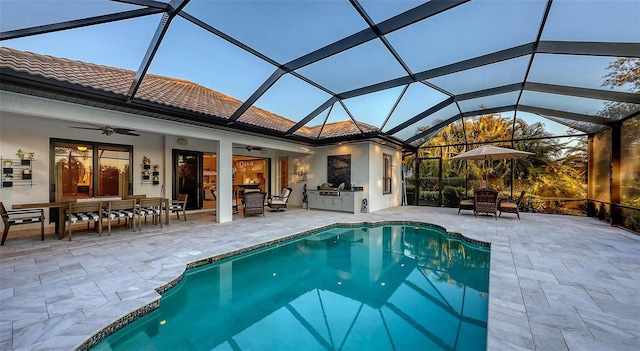 view of swimming pool featuring ceiling fan, area for grilling, a patio area, and glass enclosure