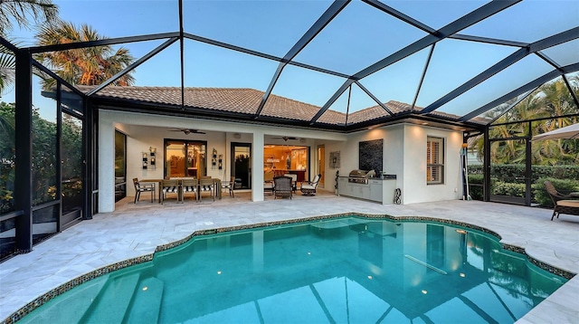 rear view of property featuring ceiling fan, area for grilling, a lanai, and a patio