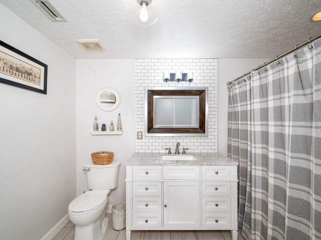 bathroom featuring vanity, tile patterned floors, a textured ceiling, and toilet