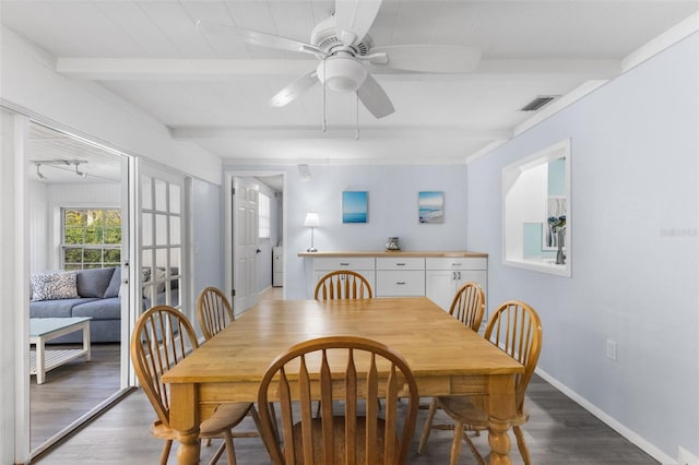 dining room featuring a ceiling fan, visible vents, beamed ceiling, and wood finished floors