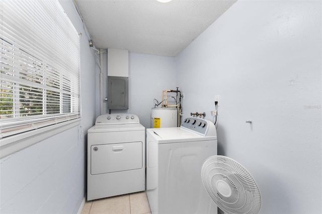washroom featuring electric panel, laundry area, water heater, washer and dryer, and light tile patterned floors