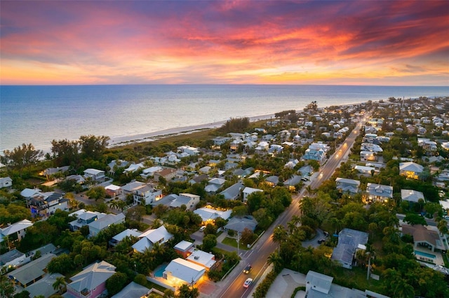 aerial view at dusk featuring a residential view and a water view