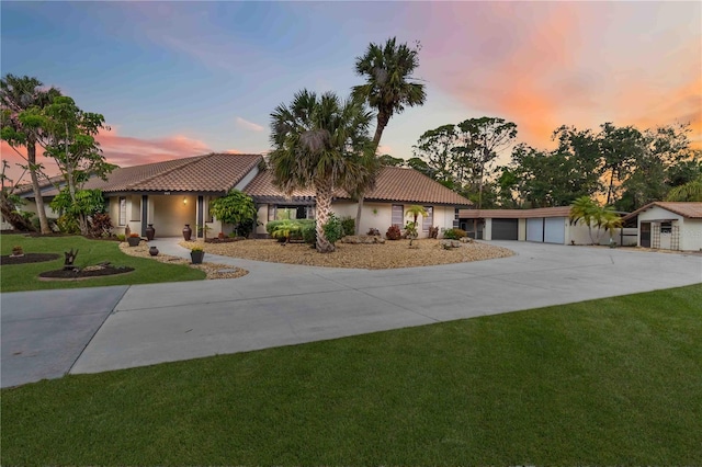 mediterranean / spanish home featuring a garage and a lawn