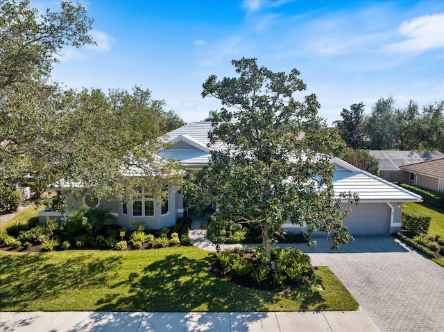 obstructed view of property featuring a garage and a front lawn