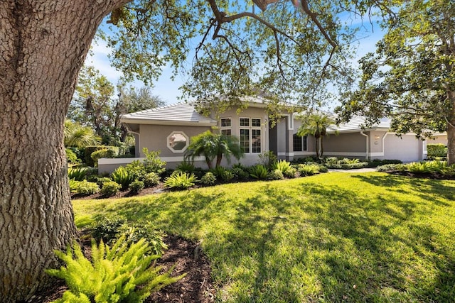 ranch-style house with a garage and a front lawn