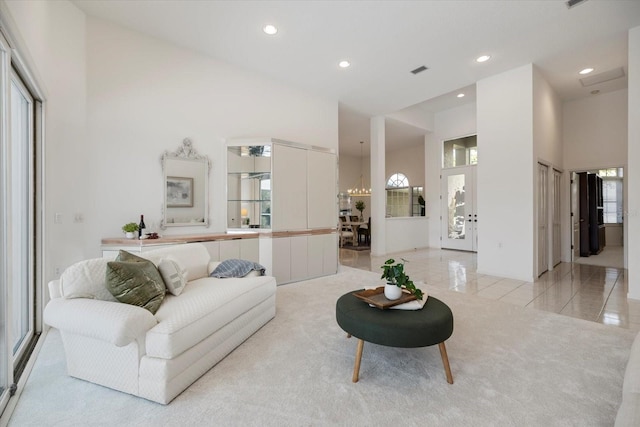 tiled living room with a healthy amount of sunlight and a high ceiling