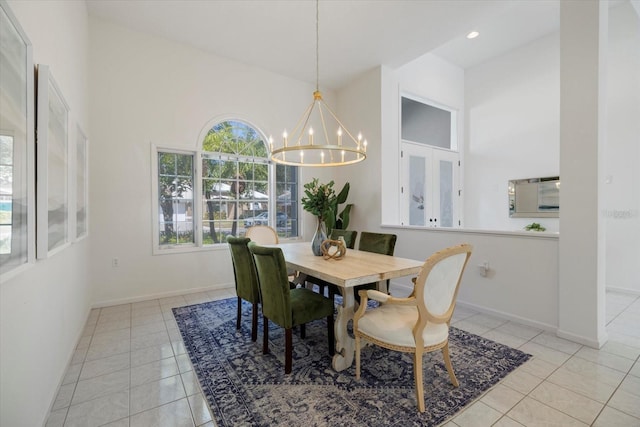 tiled dining area featuring a towering ceiling and a notable chandelier