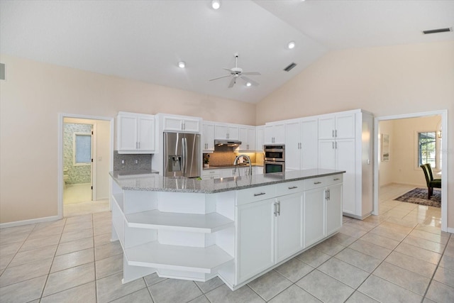 kitchen featuring appliances with stainless steel finishes, a large island, white cabinets, and dark stone counters