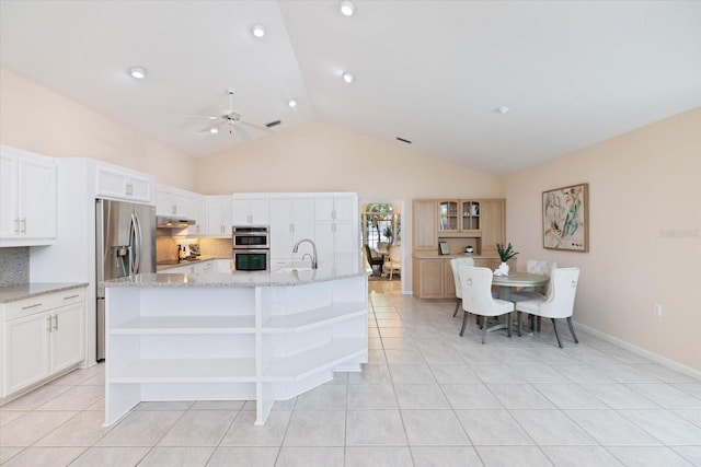 kitchen featuring sink, a kitchen island with sink, white cabinetry, light stone counters, and light tile patterned flooring