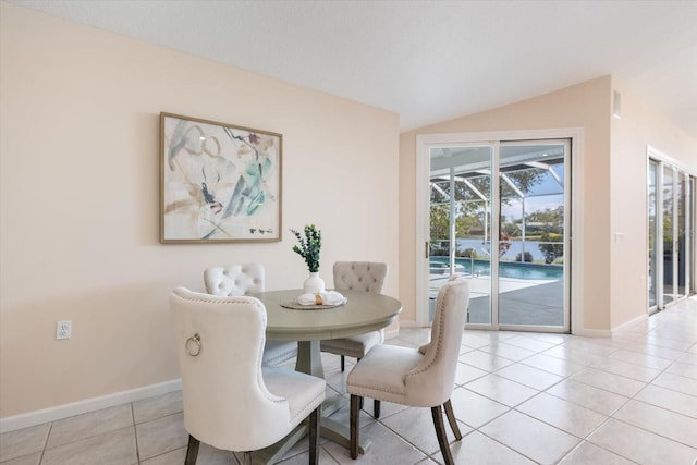 tiled dining space featuring lofted ceiling