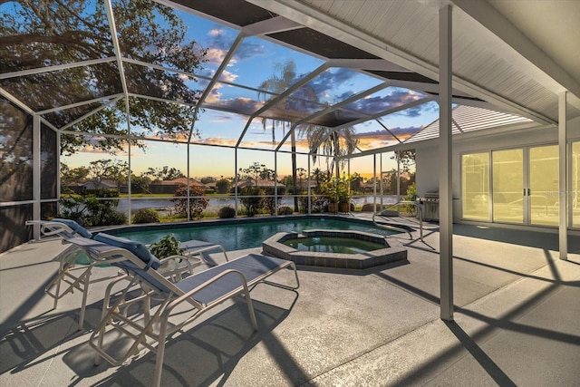 pool at dusk with a water view, an in ground hot tub, a lanai, and a patio